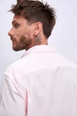 Camisa de manga larga color rosa claro con botones. Corte clásico.