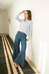 Pantalon de jean azul oscuro con corte wide leg, tiro medio y costuras frontales verticales. Presenta cierre frontal con botón a la vista.