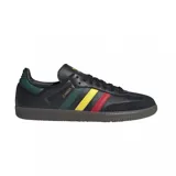Championes adidas Samba OG de diseño clásico, con exterior de cuero negro y detalles en verde, amarillo y rojo en las icónicas tres tiras laterales. Presenta puntera de gamuza, suela de goma oscura y logo dorado en el lateral.