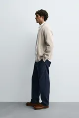 Chaqueta tipo bomber de punto en hilatura de lana, con cuello subido, manga larga, bolsillos de vivo en la cadera, acabados en rib y cierre frontal de cremallera.