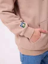 Canguro negro con capucha y estampado grande en la espalda de un paisaje con árboles, una camioneta camper y un lago al atardecer, con el logo "RUSTY" en la parte superior.