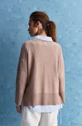 Sweater blanco de punto con diseño holgado, cuello redondo, mangas largas acampanadas y detalles de textura horizontal en el tejido.