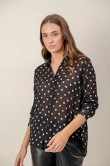 Camisa de manga larga con estampado de leopardo, cuello clásico y cierre frontal de botones. Presenta un corte holgado y puños abotonados.