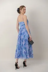 Vestido midi de tul plisado con estampado floral en tonos celestes y violetas, tirantes finos y detalle drapeado tipo corsé en el cuerpo.