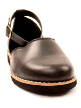 Zapato plano tipo bailarina o mary jane, color gris claro, con puntera redonda y tira de ajuste con hebilla en el tobillo. Suela negra.