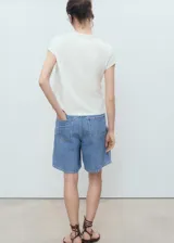 Camiseta blanca de manga corta y cuello redondo, con estampa frontal rectangular en tonos rosados con rayas verticales y la inscripción "Alla Spiaggia".