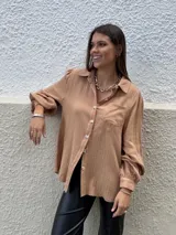 Camisa color beige de muselina con bordado en la parte delantera y mangas globo.