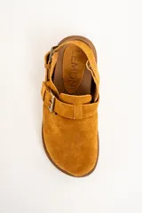 Zueco color camel de gamuza, con suela marrón y dos hebillas ajustables.