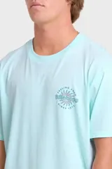 Remera Billabong de manga corta color celeste, con estampado gráfico en la espalda con diseño de una quilla de tabla de surf, un sol y la leyenda "Feeling Free Since Nineteen Seventy Three".