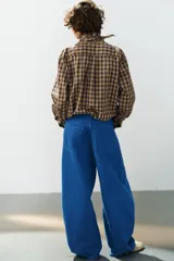 Jeans de tiro medio estilo balloon en color negro, con diseño de cinco bolsillos, trabillas para cinturón y cierre frontal con cremallera y botón metálico.