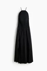 Vestido largo color negro con cuerpo de crochet en la parte superior, escote halter con tirantes finos y falda fluida con leve vuelo confeccionada en mezcla de lyocell. Presenta diseño de espalda descubierta.