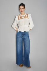 Jean de corte oxford y tiro medio, confeccionado en denim de color azul clásico. Presenta un diseño de pierna ancha y holgada, con cierre frontal y bolsillos laterales y traseros.