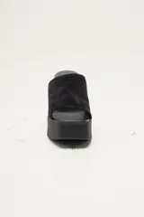 Zapato de plataforma tipo sueco, de empeine amplio en ante, con plataforma alta y taco ancho. Puntera cuadrada y diseño abierto en el talón.