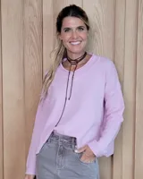 Sweater de punto color rosa pastel, con cuello redondo y mangas largas de corte holgado.