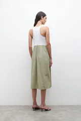 Vestido midi con parte superior blanca tipo musculosa y falda verde con rayas verticales blancas.
