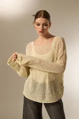 Sweater de tejido de punto calado con lurex, cuello redondo a la base y mangas largas con diseño holgado.