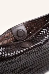 Cartera tipo morral y bandolera de cuero vacuno marrón, completamente trenzada a mano con diseño estructurado y correa larga trenzada.