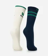 Kit de dos pares de medias deportivas de caña larga. Un par es blanco con el logo "W" de Wilson en verde y el nombre "Wilson" en azul, y el borde superior en verde. El otro par es azul marino con dos rayas verdes en la parte superior y el logo "W" de Wilson en verde en el lateral. Confeccionadas en algodón, poliamida y elastano.