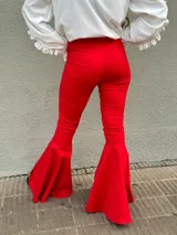Pantalón negro de tiro alto con corte acampanado y terminación en volado en el ruedo.