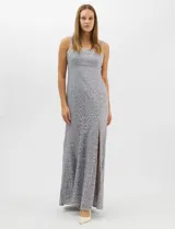Vestido largo de encaje color gris, con escote recto adornado con aplicaciones de pedrería y perlas. Presenta breteles anchos y una abertura lateral en la falda.