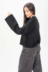 Sweater de tejido de punto color marrón, con cuello redondo y mangas largas anchas de tipo acampanado.