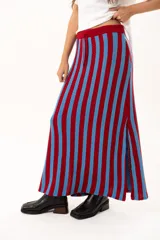 Pollera midi tejida a rayas verticales en color rojo y celeste, con pretina elástica, cordón de ajuste y tajos laterales profundos.