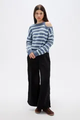 Sweater de punto a rayas horizontales en tonos azules y blancos, con diseño holgado, cuello redondo y abertura tipo cut-out en uno de los hombros.