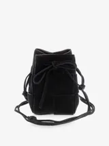 Cartera tipo bucket de cuero negro con diseño tejido, cierre de cordón ajustable y correa larga para llevar al hombro o cruzada.