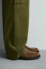 Mocasín color marrón de piel serraje, con antifaz y hebilla metálica.