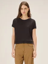 Remera Sali negra de punto fino, con cuello redondo, mangas cortas y costuras decorativas frontales.