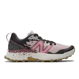 Championes de trail running New Balance Fresh Foam X Hierro v7, con diseño técnico en tonos rosado, negro y detalles en color tierra. Presentan suela Vibram Megagrip para mayor tracción, entresuela con tecnología Fresh Foam X para amortiguación y empeine de malla transpirable.