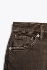 Bermudas de denim color marrón oscuro, tiro medio, con cinco bolsillos y dobladillo deshilachado.