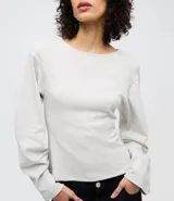 Blusa de algodón color beige con cuello redondo y mangas largas amplias de corte holgado. Presenta un diseño minimalista con costuras sutiles y ajuste regular al cuerpo.