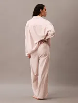 Pantalón de pijama de corte relajado y pernera ancha, confeccionado en popelina de algodón. Presenta cintura elástica con etiqueta de marca y bolsillos laterales.