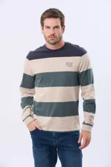 Remera de manga larga con diseño de rayas horizontales anchas en tonos verde, bordó y azul marino. Presenta cuello redondo y una pequeña estampa tipográfica en el pecho.