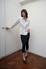 Camisa de satén blanca con calce entallado, manga larga con puños clásicos y cierre frontal con botones ocultos.