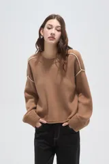 Sweater de algodón color natural, de corte holgado y cuello redondo. Presenta detalles de costuras decorativas con bordado en los hombros y puños acanalados.
