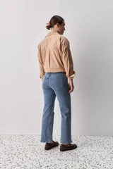 Jean de corte recto en color gris lavado, con detalle de bordados circulares a lo largo de las costuras laterales. Presenta un diseño de tiro medio y calce relajado.