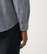 Camisa de manga larga color celeste con textura, cuello camisero, cierre frontal con botones y dos bolsillos de parche en el pecho.