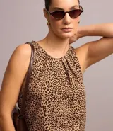 Blusa sin mangas confeccionada en crepé con cuello redondo con pliegues delanteros y cierre delantero por gota y estampa animal print de leopardo.