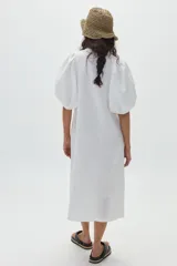 Vestido midi de lino color blanco, con mangas abullonadas hasta el codo, cuello mao y botonadura frontal con botones de nácar.