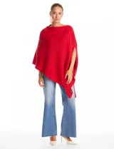 Poncho tejido de punto con diseño asimétrico y aberturas laterales para los brazos.