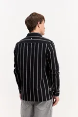 Camisa de manga larga color beige, de tejido texturado con cierre frontal de botones y cuello camisero clásico.