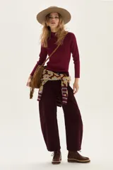 Polera de tejido de punto acanalado en color beige, con cuello alto y mangas largas. Presenta un sutil acabado brillante gracias a sus detalles en lurex.