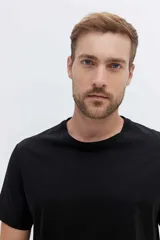 Remera de algodón verde militar, de corte clásico con cuello redondo y mangas cortas.