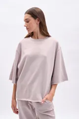 Remera oversize de manga corta con efecto lavado en color beige, cuello redondo y terminaciones deshilachadas.