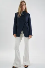 Blazer entallada de Zara Woman Collection, color azul marino, con cuello subido y detalle de tejido a contraste. Presenta cierre frontal cruzado con botones, manga larga y bolsillos con solapa en el delantero. Incluye forro interior.