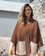 Saco tejido de punto en color marrón chocolate, con corte holgado y mangas anchas. Presenta cierre frontal con botones y dos bolsillos delanteros grandes en material metalizado color champán.