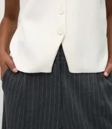 Chaleco Marfinno de corte recto y largo, confeccionado en tricot. Presenta cuello en V, cierre frontal con botones y diseño liso sin estampados.