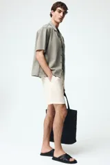 Short texturizado de mezcla de viscosa, color beige, con cintura elástica con cordón de ajuste y bolsillos laterales.